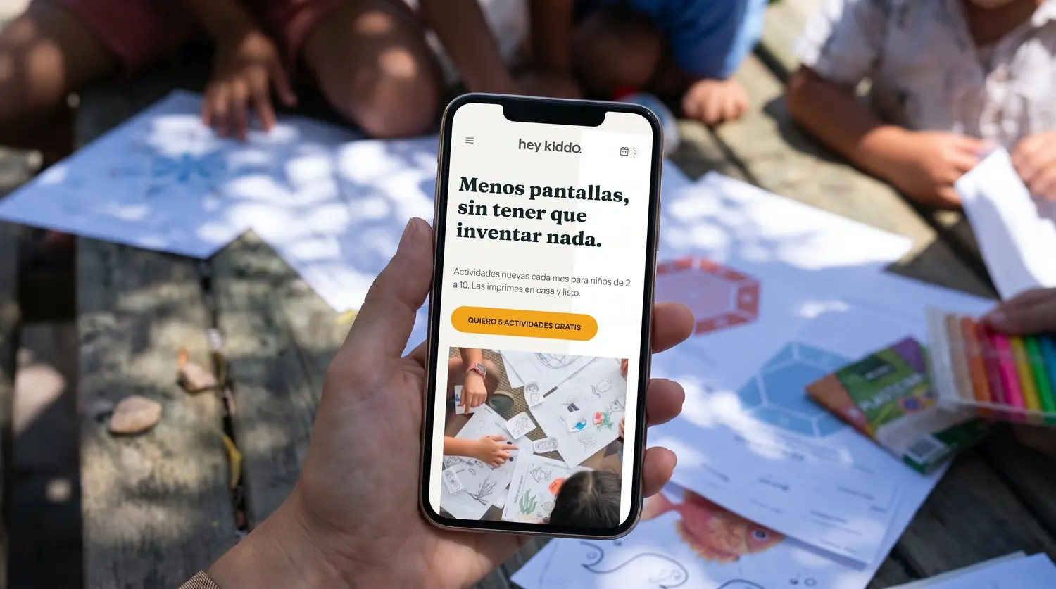 La portada de heykiddo.cl en un celular, rodeada de niños usando el material impreso
